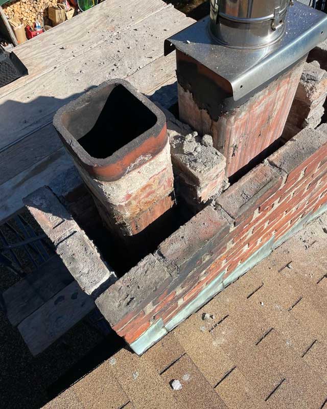 A handyman repairing a brick chimney