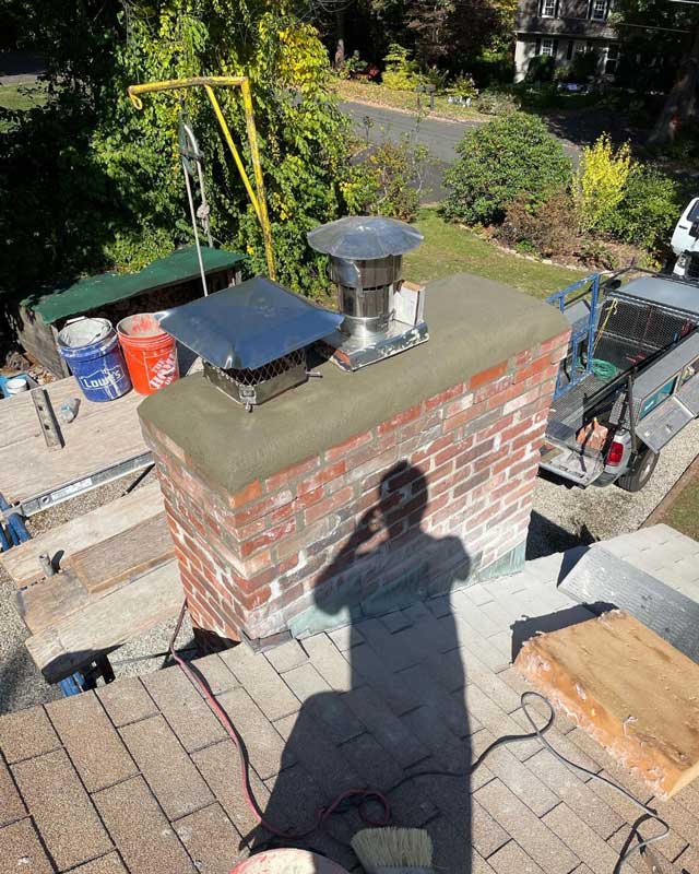 A handyman repairing a brick chimney