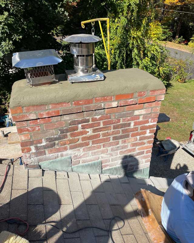 A handyman repairing a brick chimney