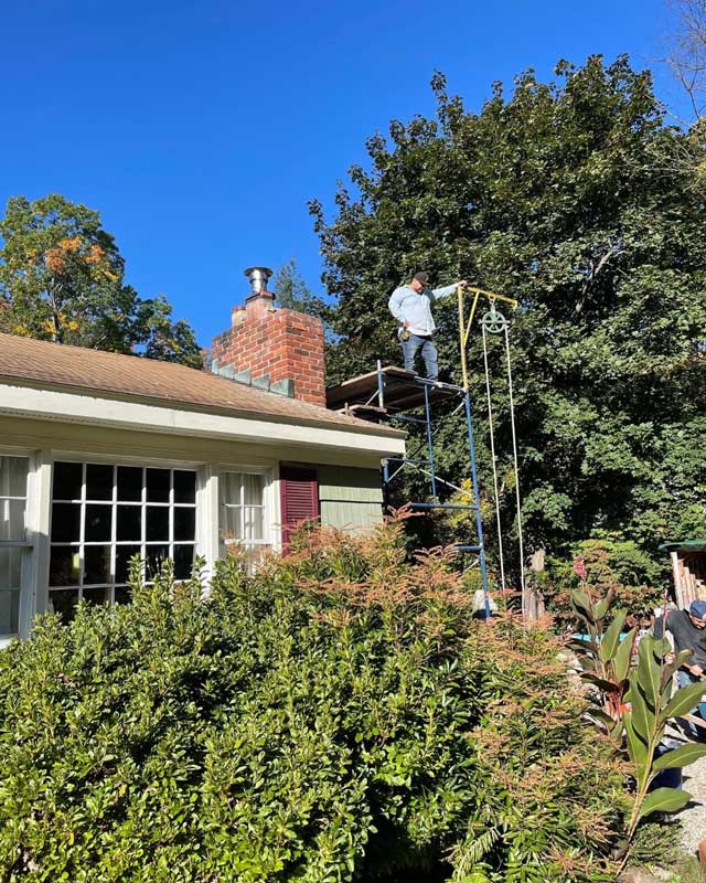 A handyman repairing a brick chimney