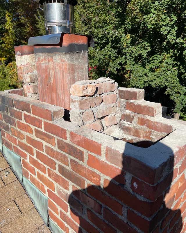 A handyman repairing a brick chimney