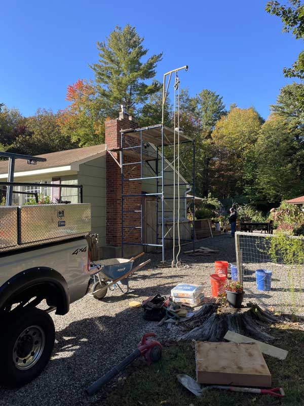 A handyman repairing a brick chimney